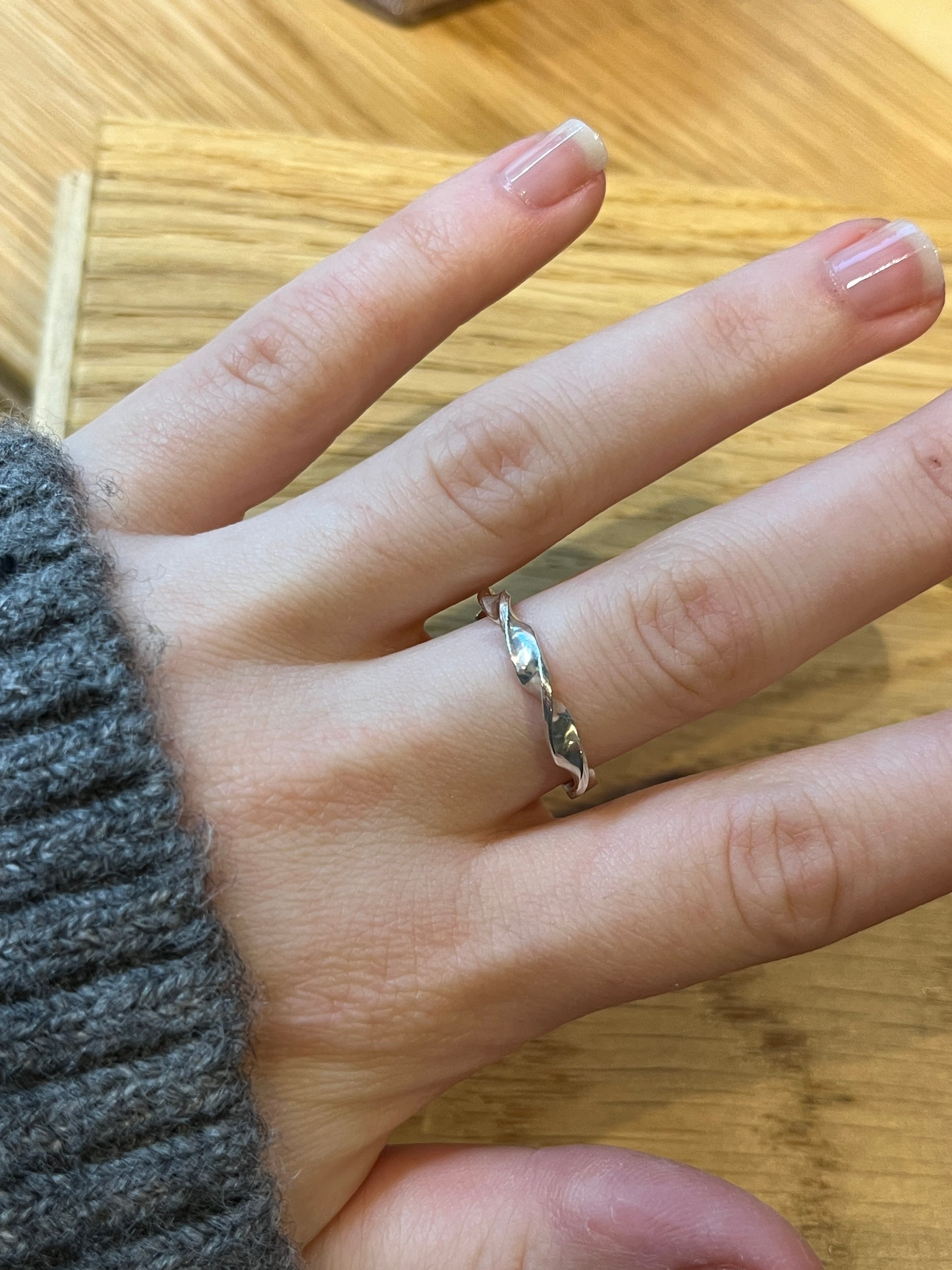 The helix band modelled on hand against wooden backdrop