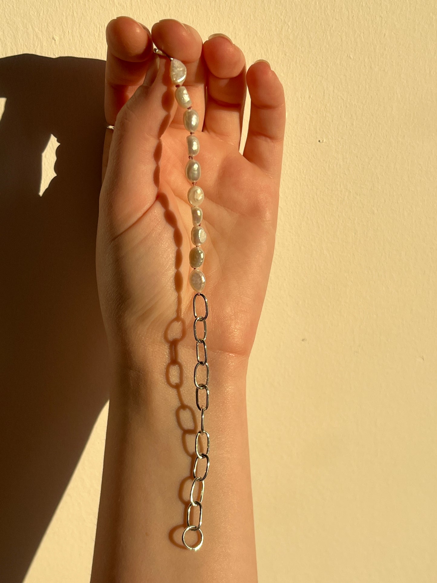 the astrophel bracelet laid out flat showing the 50/50 split between chain and pearls.