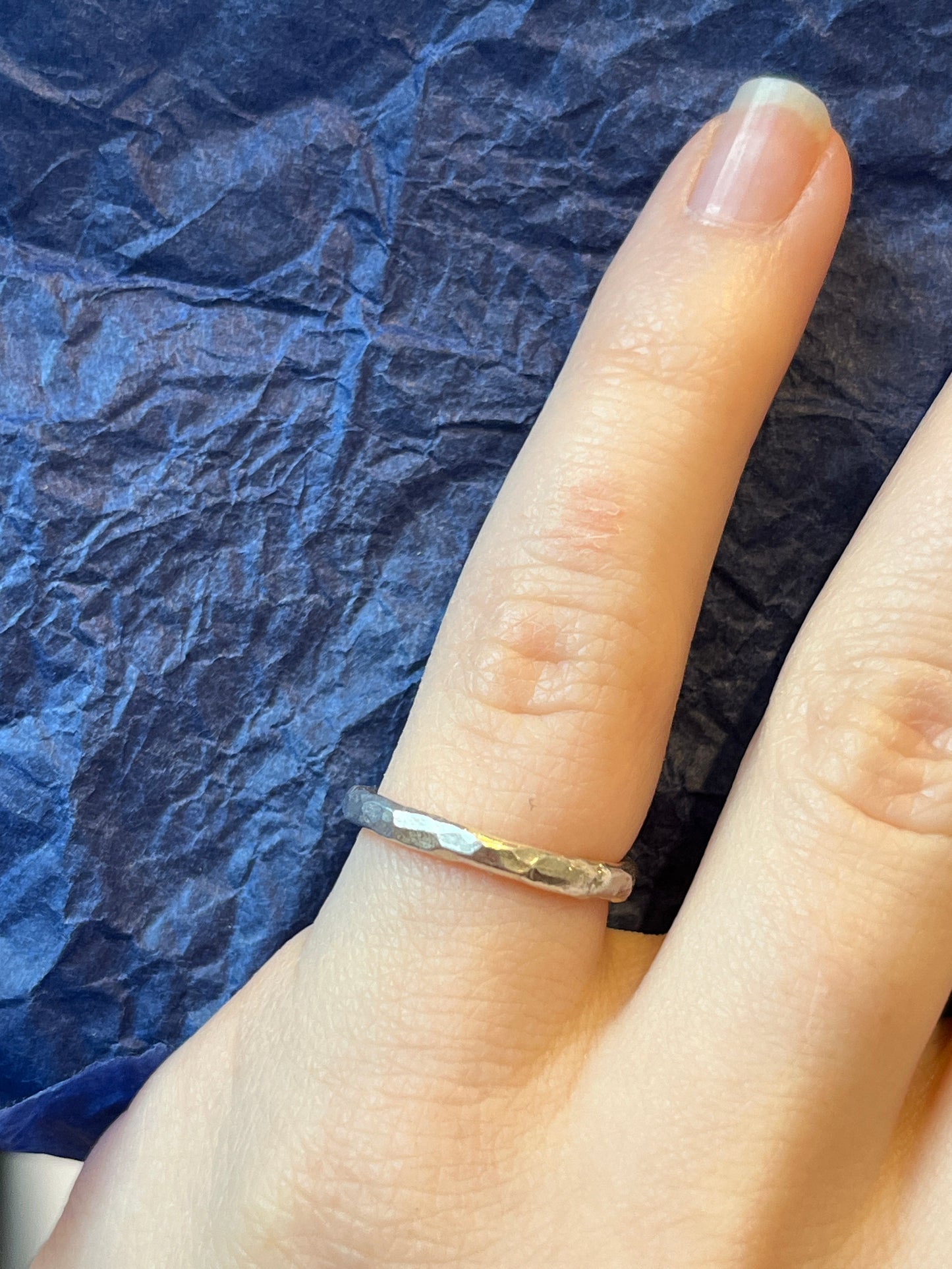 the high polished hammered ring an be seen on a pinky finger