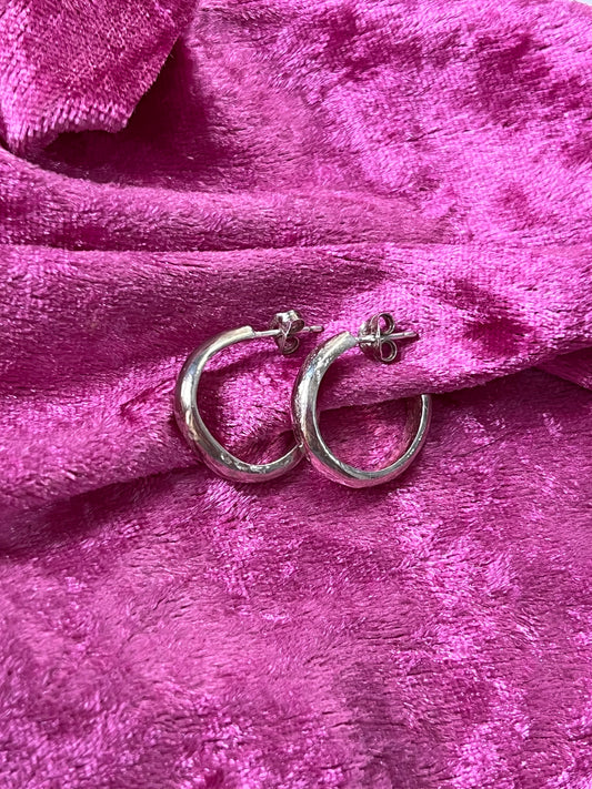 sterling silver hoops with dimpled texture against flat on pink fabric