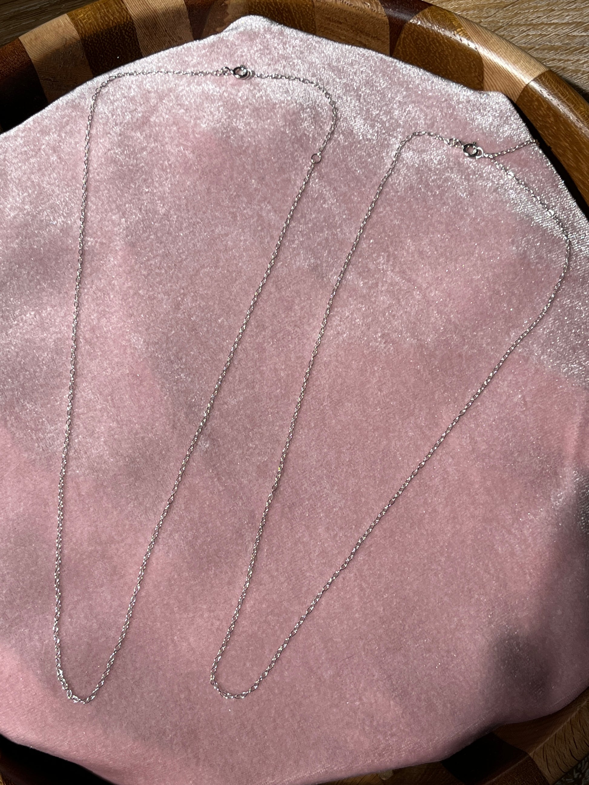 Close-up picture if the 16-18" extendable chain on a pink velvet background