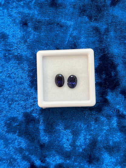Two deep, dark blue stones in a white box on a blue textured background