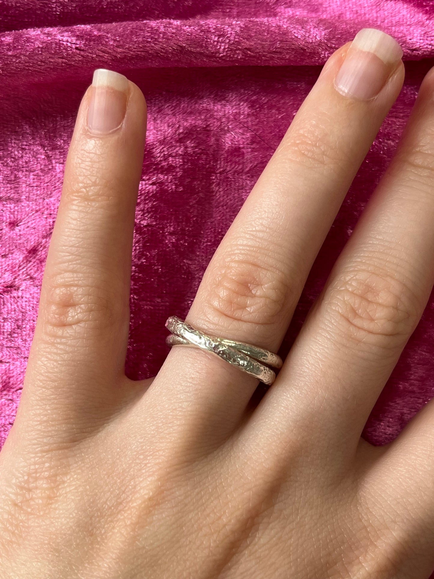 a sterling silver ring, made up of two interlocked d shape sterling silver bands. One band has a smooth texture and the other has a rough texture resembles the surface of the moon.