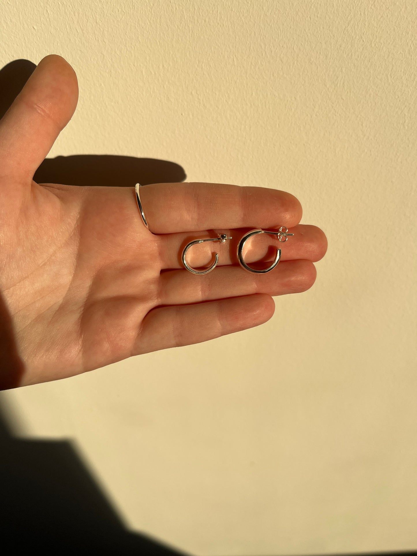 the smooth hoop on the right pictured against the simple silver hoops of the left.