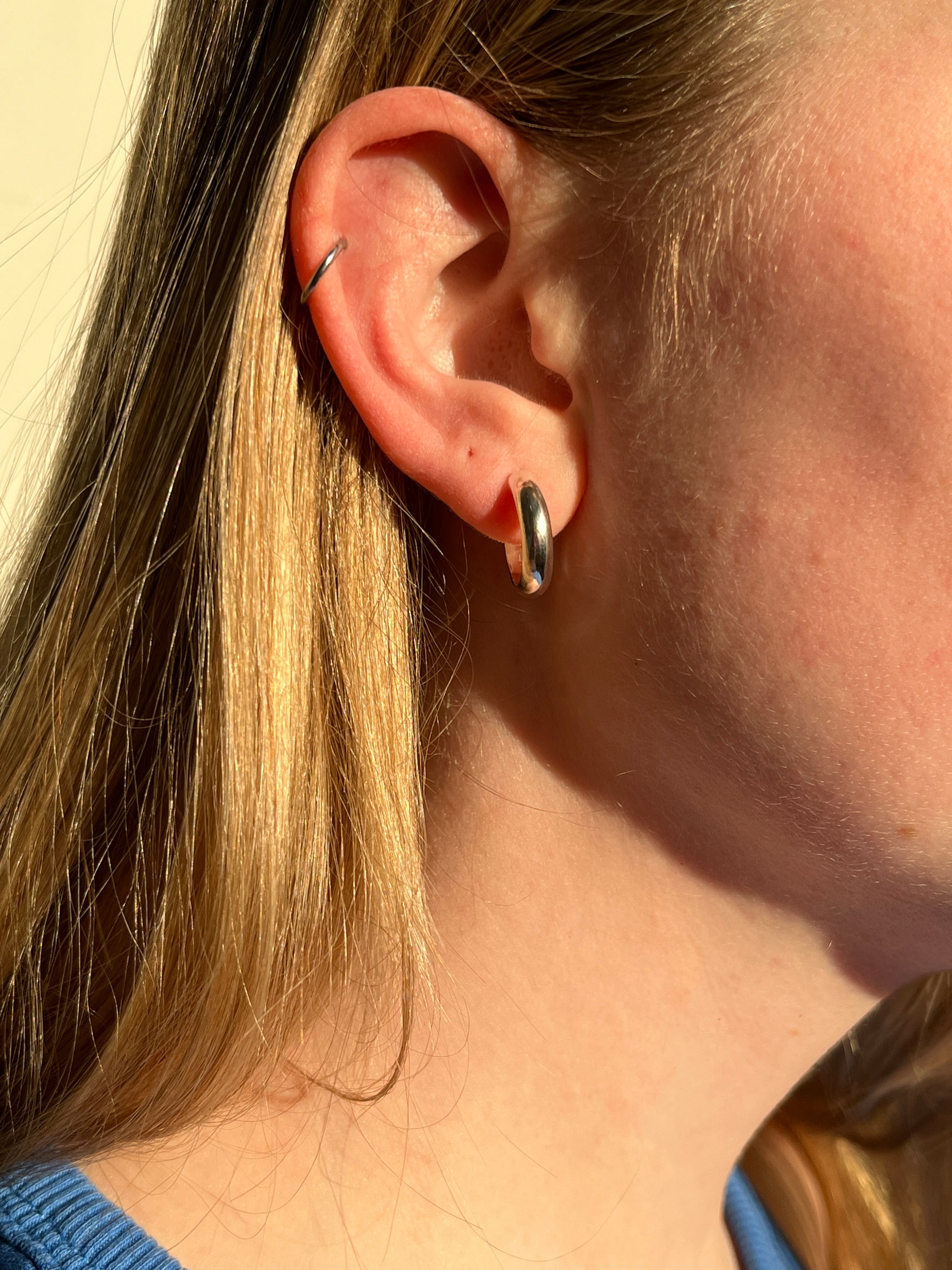 a closeup of the smooth hoop styled in someones ear